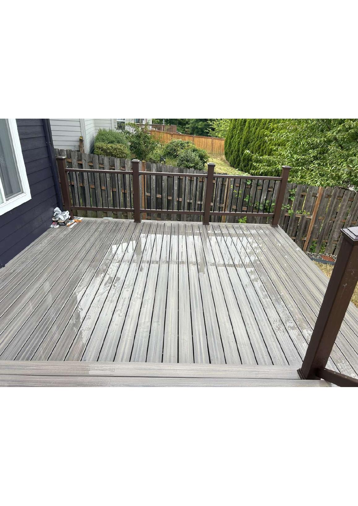 Restored wood deck surface and brown railing
